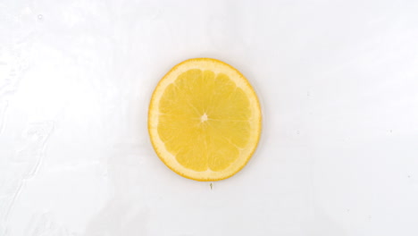 Frische-Zitrone-Auf-Der-Draufsicht,-Das-Wasser-Strömt-Auf-Weißem-Hintergrund.